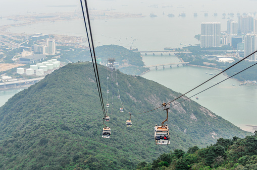 The Ngong Ping 360 is an aerial tramway on Lantau Island in Hong Kong. Photo taken contains the cable cars and passengers en route to the top of Lantau Island in Hong Kong.