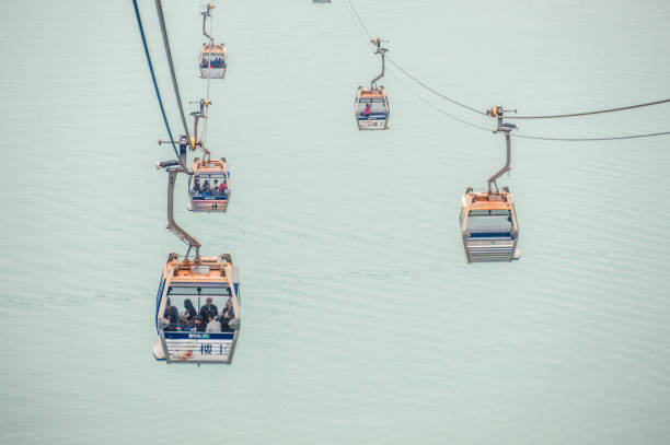 The Ngong Ping 360 is an aerial tramway on Lantau Island in Hong Kong. Photo taken contains the cable cars and passengers en route to the top of Lantau Island in Hong Kong.