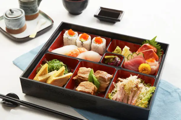 A bento box full of various kinds of sushi, tempura of Japan on white background