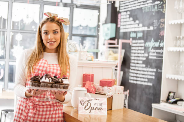 istock Small business owner holding cakestand with cupcakes 643844592