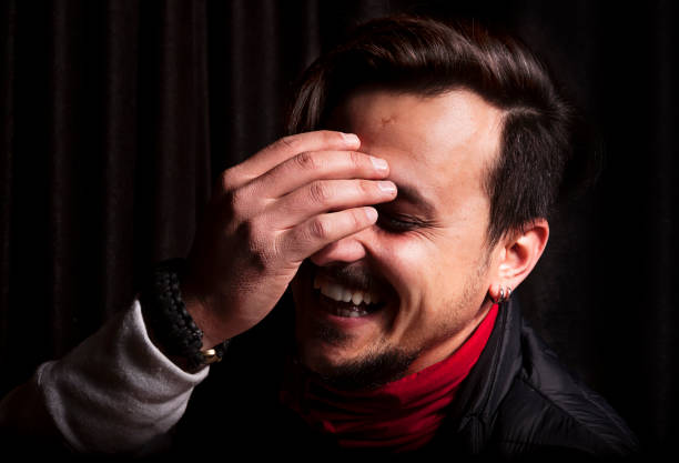 istock Laughing low-key man closeup portrait with black background 643848490