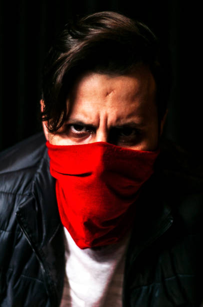 istock Red masked low-key man closeup portrait with black background 643848504