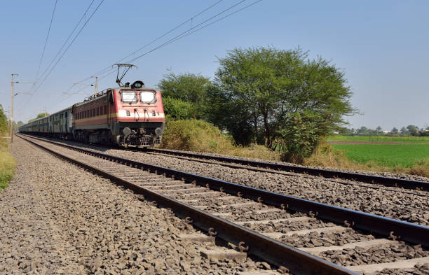 Indian Railway - Long Distance Train Indian long distance train passing near wheat field india train stock pictures, royalty-free photos & images