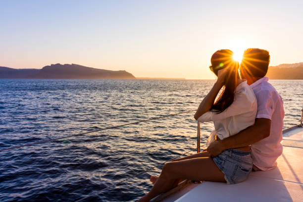 Romantic couple on yacht at sunset Romantic couple on yacht at sunset in Greece sunset cruise stock pictures, royalty-free photos & images