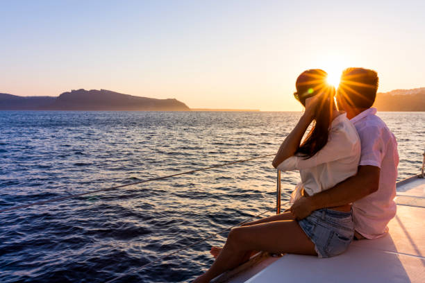 Romantic couple on yacht at sunset Romantic couple on yacht at sunset in Greece happy couple on vacation in santorini greece stock pictures, royalty-free photos & images