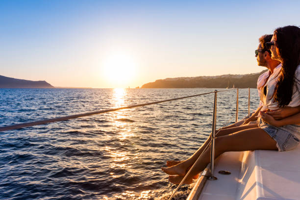 Romantic couple on yacht at sunset Romantic couple on yacht at sunset in Greece happy couple on vacation in santorini greece stock pictures, royalty-free photos & images