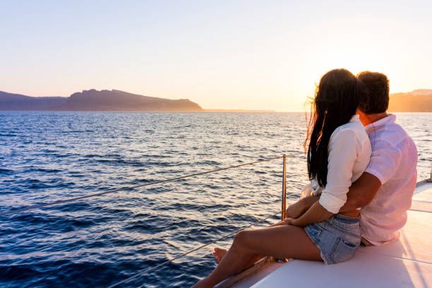 Romantic couple on yacht at sunset Romantic couple on yacht at sunset in Greece happy couple on vacation in santorini greece stock pictures, royalty-free photos & images