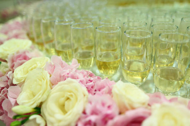 Close-up of a glass of champagne and bouquet of roses