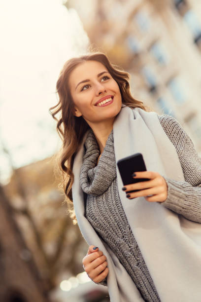 istock Young woman texting outdoors 643868396