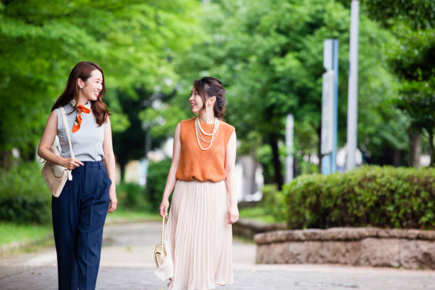 femmes de marcher dans le parc - girl talk photos et images de collection