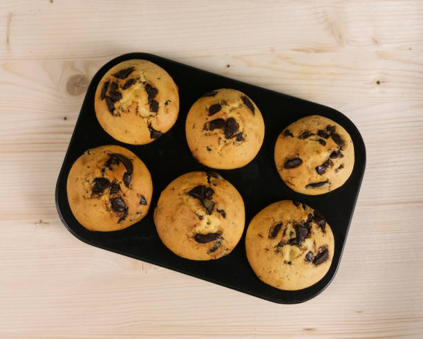 istock Muffin with chocolate drops on wood background - top view 643891128