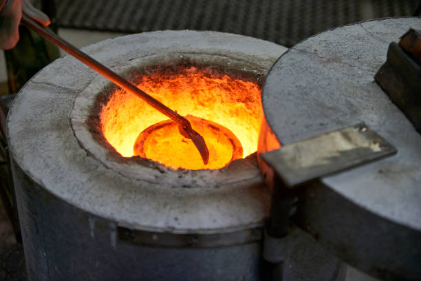 Sculpture artist's workshop. The artist is melting the bronze metal alloy in the oven before filling the casting mold with with the hot metal.