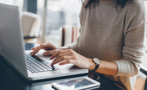 Woman using her laptop Young businesswoman in casual clothing spotting stock pictures, royalty-free photos & images