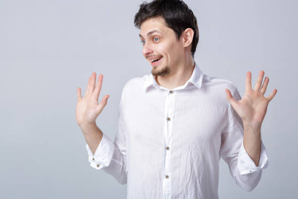 istock young attractive smiling brunette man in white shirt on gray bac 643898494