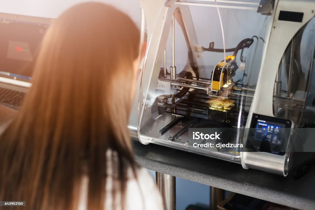 Woman working with 3d printer Young woman in white lab coat working with 3d printer 3D Printing Stock Photo