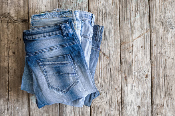 istock Blue jeans on wooden background 643902308