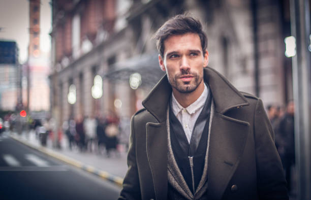 Modern man in winter coat Handsome businessman having a walk in the town, enjoying the free time away from work. well dressed stock pictures, royalty-free photos & images