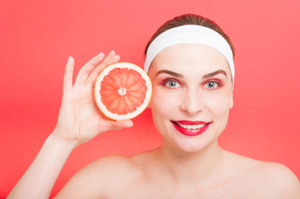 istock Beautiful young woman holding grapefruit 643919264