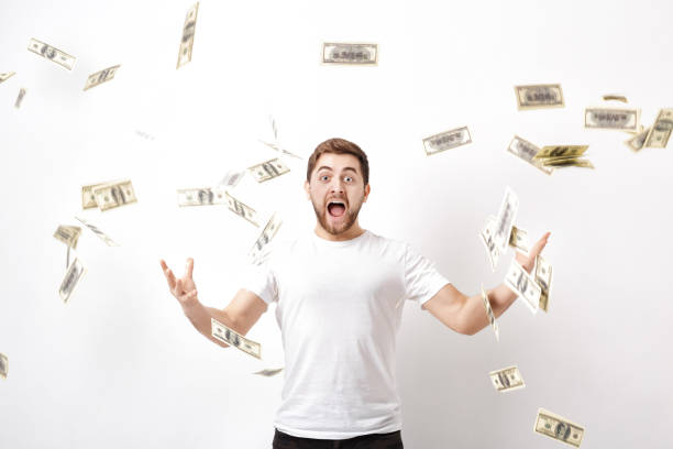 istock young happy man with a beard in white shirt standing under money 643924550