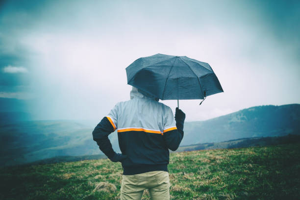 istock Man in nature holding umbrella. 643926760