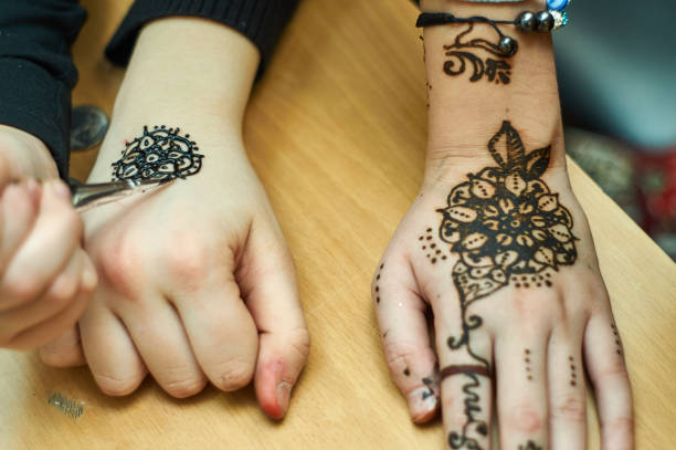 istock Talented girl draws patterns by henna on the hands 643926986