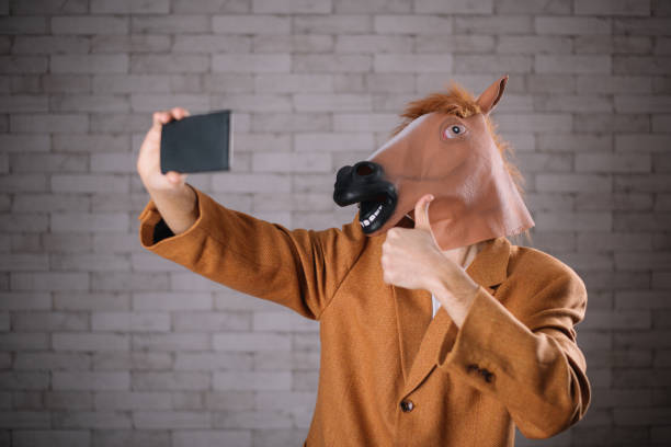 istock Man with horse mask taking a selfie 643930968