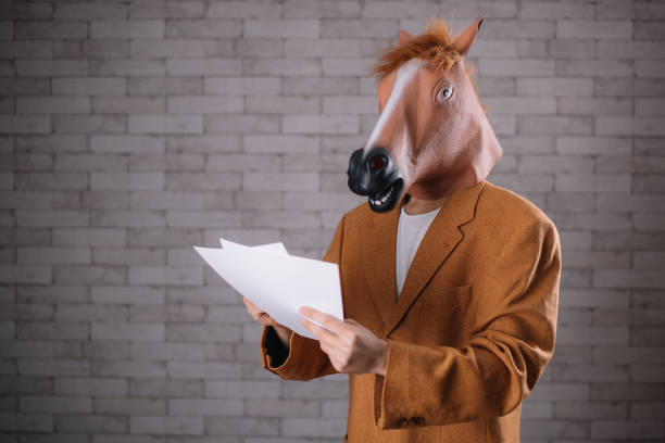istock Man with horse mask browsing through papers 643931062