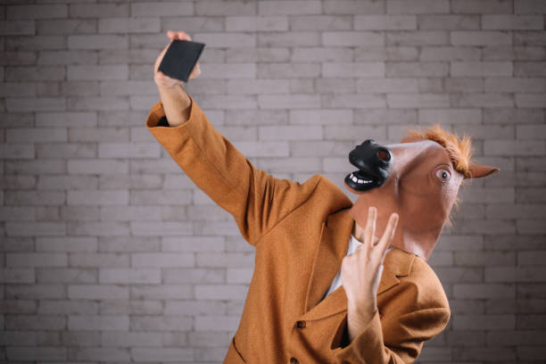 uomo con maschera da cavallo che si fa un selfie - horse men animal head bizarre foto e immagini stock