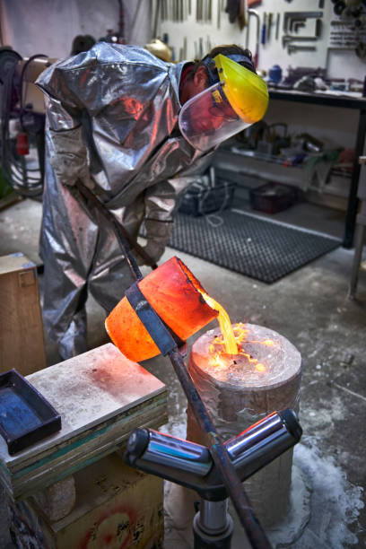 istock Artist fills mold with molten bronze 643932010