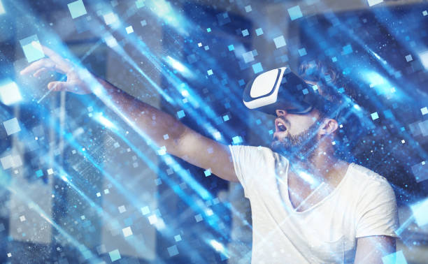 istock Young man with VR glasses playing virtual reality touching polygons 643942892