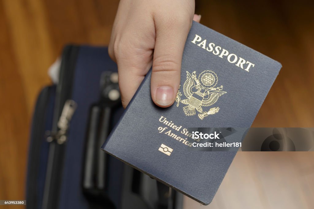 checking in at airport female hand presenting passport above suitcase Passport Stock Photo