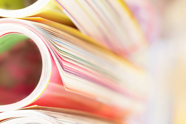 istock edge of colorful magazine stacking roll with  blurry bookshelf background 643956794