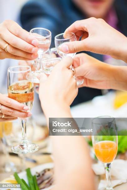 Holiday Event People Cheering Each Other With Champagne And Vodka Stock Photo - Download Image Now