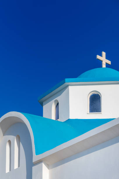 A church with a blue dome and a white cross against a blue sky. Kos, Greece This image is GPS tagged