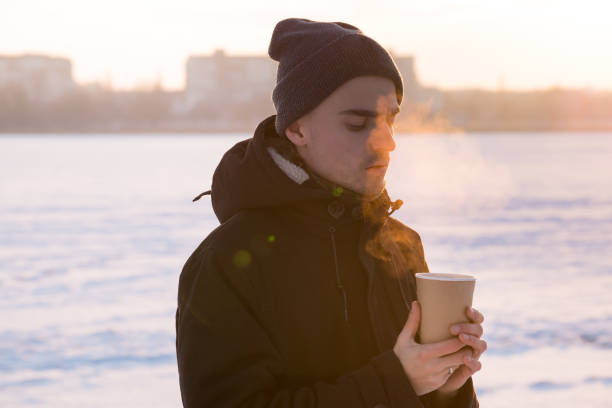 istock Hot steaming drink in male hands outside 643969710
