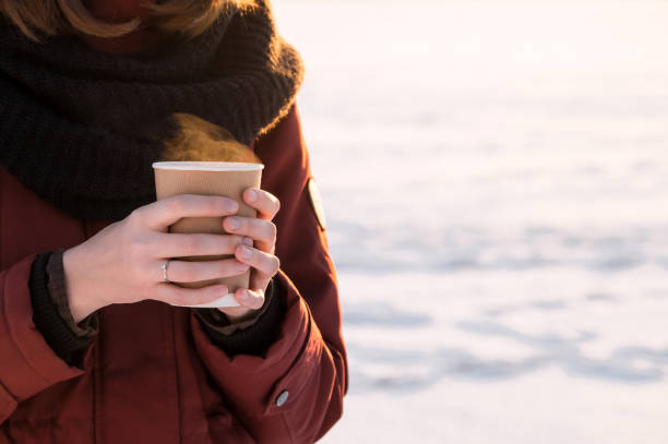 istock Person with cup of hot coffee outdoors at sunset 643969716