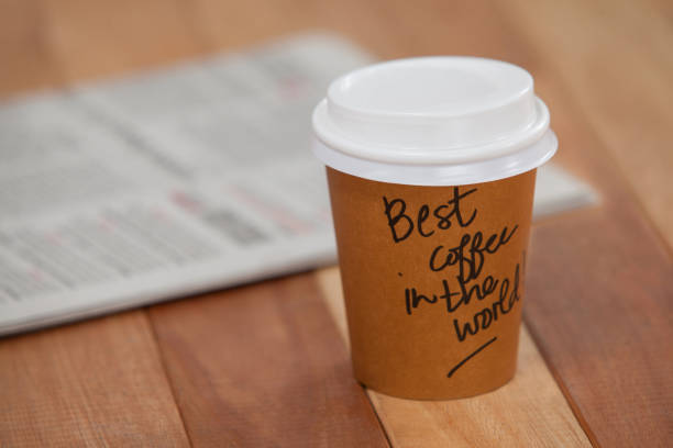 istock Close-up of disposable coffee cup and newspaper 643974176