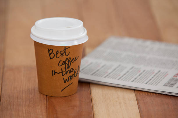 istock Close-up of disposable coffee cup and newspaper 643974366
