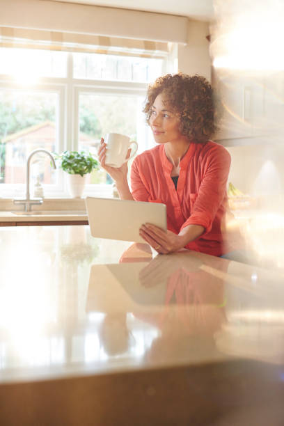 istock woman thinking in her kitchen with a cuppa. 643980800