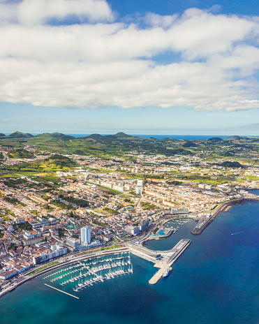 Aerial view on the harbour and waterfront of Ponta Delgada and over coastline and landscape island of Sao Miguel, Azores