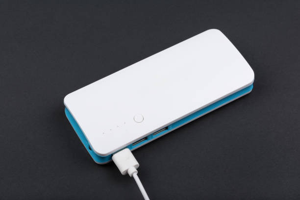 istock Portable power bank for charging mobile devices on dark background 643985232