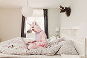 Woman in unicorn costume in bedroom