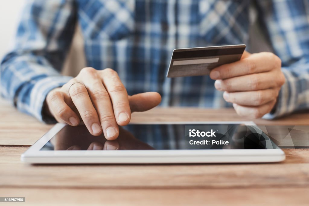 Man shopping online with digital tablet and credit card Businessman using tablet computer and credit card. Online shopping concept Online Shopping Stock Photo