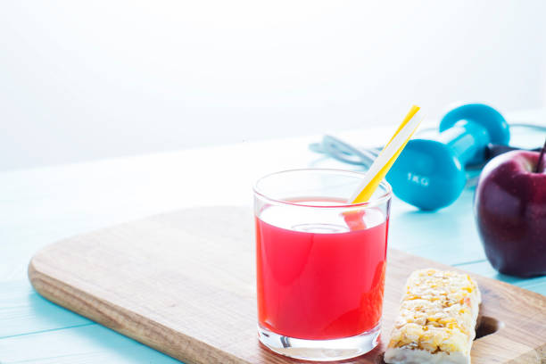 The concept of weight loss, jump rope, dumbbell,  juice, cereal bar and red apple. Healthy lifestyle. Morning healthy nutrition. Sport and diet.