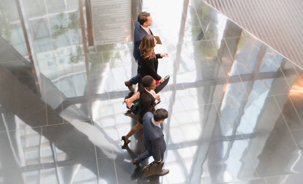 istock Corporate business people walking in modern lobby 643999069