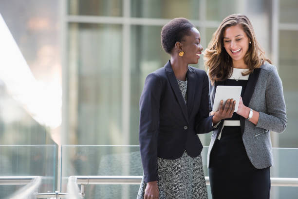 istock Smiling corporate businesswomen using digital tablet 643999359