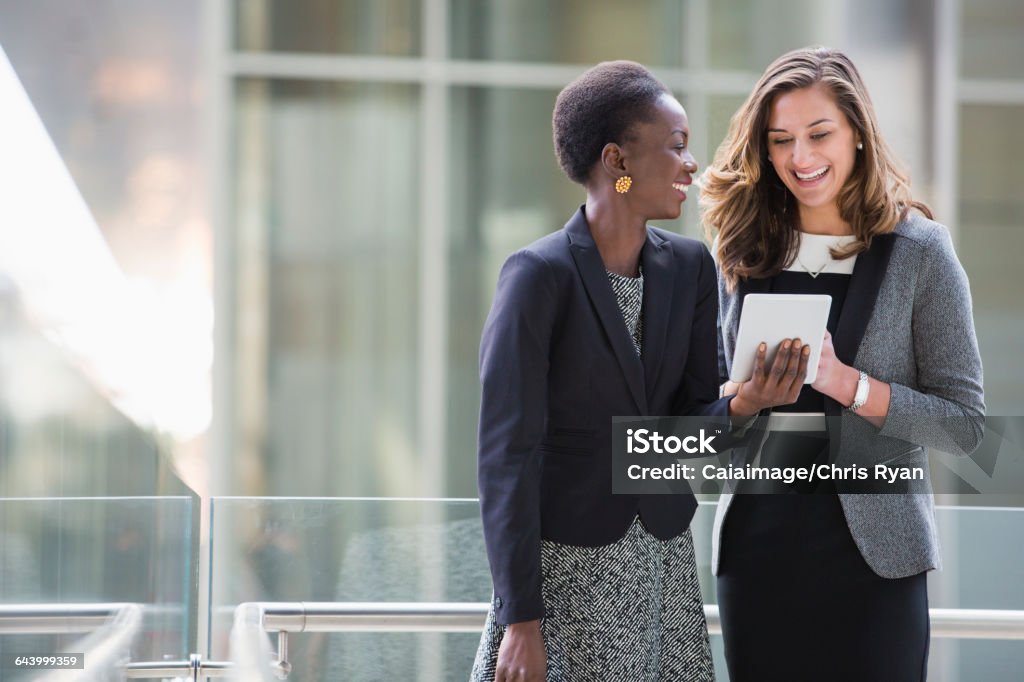 Smiling corporate businesswomen using digital tablet  Business Stock Photo