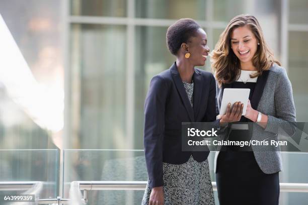 Smiling Corporate Businesswomen Using Digital Tablet Stock Photo - Download Image Now