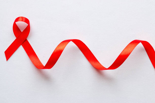 símbolo vermelho da fita do dia de aids do mundo - aids awareness ribbon ribbon red swirl - fotografias e filmes do acervo