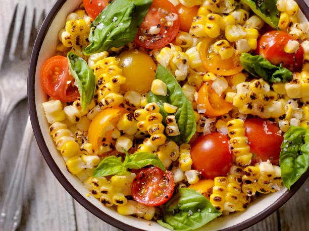 gegrillter maissalat mit tomaten und basilikum - vom holzkohlengrill stock-fotos und bilder